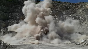 Powerful Industrial Quarry Blast Creating a Massive Dust Cloud, Showcasing Rock Excavation and Mining Operations in a Rugged Landscape