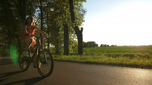 Girl riding a bike on a warm evening - Free Stock Video