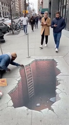 NYC sidewalk illusion shocks pedestrians as man appears to fall into “hole” New York City, New York — February 14, 2026 Video recorded in Manhattan shows a hyper-realistic 3D sidewalk illusion startling pedestrians when one man appears to fall directly into what looks like a gaping hole in the pavement. The footage captures a detailed chalk artwork designed to resemble a deep crater carved into the busy sidewalk. Complete with shadowing and crumbling edges, the illusion blends almost seamlessly 