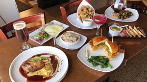 All of our Juniper classics on one table! Whipped Goat Cheese, Mushroom Fritto, Beet & Goat Cheese Salad, Fried Chicken Sandwich and our delicious Grilled Double Bone Pork Chop. | Juniper Restaurant