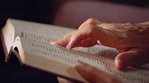 Old woman's hand. Elderly female hands pointing fingers over a book.