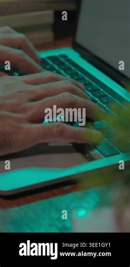 Hands working on a laptop keyboard in a calm indoor setting, highlighting concentration and a clean, modern digital workspace Stock Video Footage - Alamy