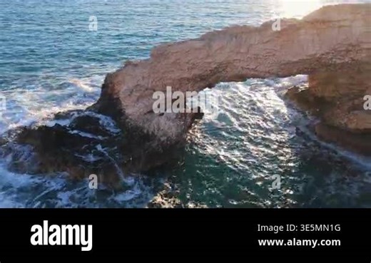 Aerial drone view of the Bridge of Love, a natural rock arch formation in Ayia Napa, Cyprus. Turquoise waves flow beneath the limestone arch Stock Video Footage - Alamy