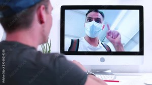 Men make video conversation using the Internet. A guy in a mask on his face talks about the quarantine conditions in a public place. Exchange of messages and emotions in telecommunication.
