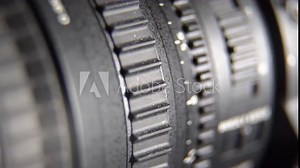 Video recording with professional camcorder extreme closeup. Adjusting camera zoom lens control ring. Pushing start stop record button. Turned on status indicator.