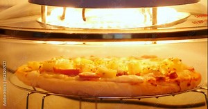 4K footage Close-up Front view Time-lapse, Hawaiian pizza in the oven is being cooked and ready to eat.