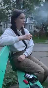 girl smoking on the bench outside and crush her cigarette
