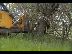 John Deere 850J pushing trees