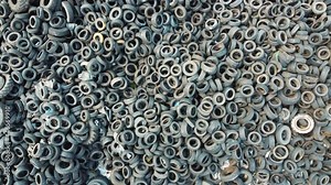 Lots of discarded tires at tire dump. Pile of old tires and wheels for rubber recycling. Industrial factory for the processing of waste tires. Environmental pollution, Ecology, Recycling.