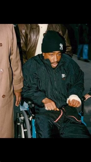 The Real Trinity Collective on Instagram: "November 30, 1994 — New York City. A cold night where the steam off the street looked like spirits rising out of the asphalt. Tupac walks into Quad Studios thinking it’s work, music, progress. Instead he walks straight into a chapter of American mythology. Five shots. Studio lobby. Close range. The kind of thing that’s supposed to end a man — not wake him up. December 1. The very next morning. He rolls into court in a wheelchair, bandaged like a field m