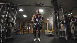 Male bodybuilder training chest muscles exercise using cable cross over machine for body mass. Workout and bodybuilding sport concept. Man in gym doing pulls weight exercise in slow motion.