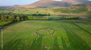 Ancient stone circle with long shadows at golden hour and view of distant mountains. Castlerigg, Lake District National Park, Cumbria, UK