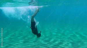 Young girl snorkeling and swimming underwater, in the clear warm ocean with sandy seabed. Turquoise water and snorkeling tourist. Travel video with the snorkeler in the sea.