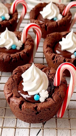 These Hot Chocolate Crinkle Cups made by Sweet Monkey hold a ganache filling and homemade marshmallow frosting topping. They're sure to be a hit on your cookie plate this year. 💚🍪❤️ Get the recipe Sweetmonkey.blog | Wilton Cake Decorating