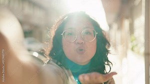 Young chinese woman smiling confident making selfie by the camera at street