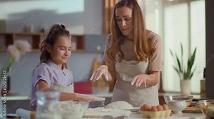 mother and daughter clapping hand on flour at kitchen in slow motion