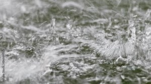 Real-time of falling water-drops with splashing over water surface macro video