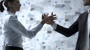 Business people giving a homie handshake, wall covered with financial reports in the background, trust and reliability concept