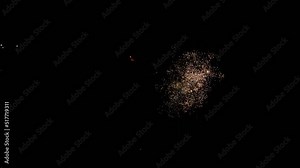 Several fireworks exploding close together lighting up the sky. Viewed from a drone camera.