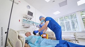 Emergency room procedures. Medical team performing defibrillation on a patient in modern operating room. Medical equipment.