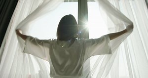 clip-1070923657-young-woman-pulling-curtains-enjoying-view-large