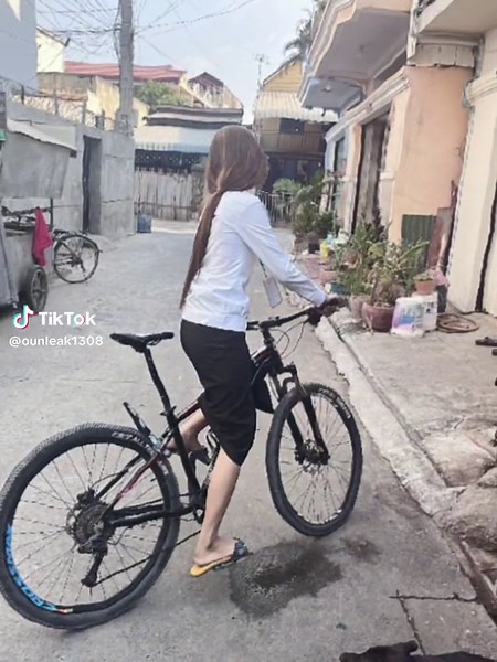 Young Woman Rides Mountain Bike in Urban Setting