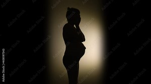 SILHOUETTE VIGNETTE of a heavily pregnant woman suddenly laughing
