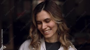 Surprised casual woman reading newspaper and open mouth, laughing while standing at home. Shocked curly girl look happy, when read good news in newspaper. Female peeps out by magazine, thumb up.