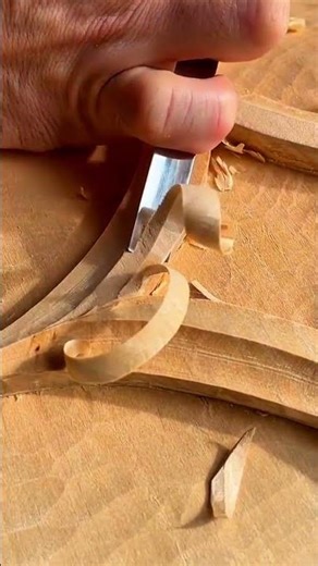 carving the wooden surface using a professional manual gouge tool for handmade woodcraft production