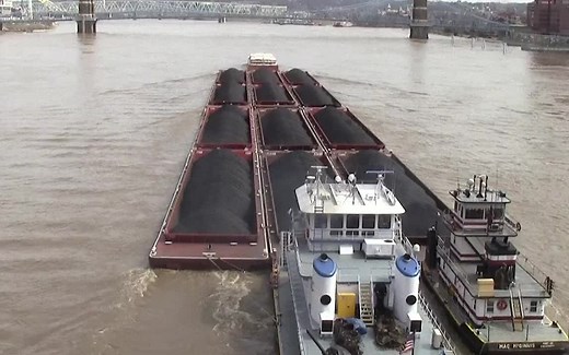 12艘运煤驳船顶着洪水逆流而上，2艘顶推船同时发力