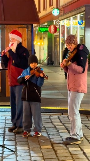 Musicians play violins in the streets.