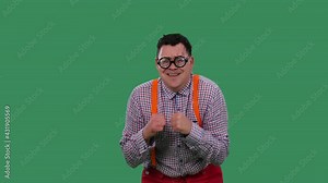 The man, hunched over, dances and sings along to the melodies. A man in glasses with thick lenses, in a plaid shirt with orange suspenders in the studio on a green screen. Slow motion. Close up.