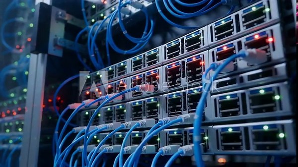 Close-up view of interconnected cables and lights illuminating a server rack in a data center