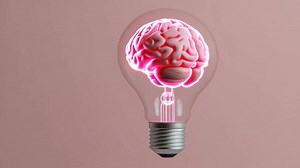 A realistic light bulb rotates on a pink background, gradually revealing a glowing pink human brain inside