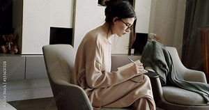 Attractive Woman freelance writer is writing his article on a notebook. idea and inspiration concept. Businesswoman writes startup business ideas and plans, creative thoughts to notebook.
