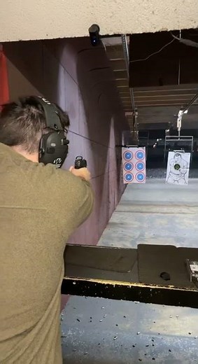 Firing a custom Sig Sauer P-230 with a red dot sight at the shooting range.