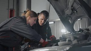 ボンネットを開けて作業している男女の自動車整備士の動画｜無料の動画素材サイト「動画AC」