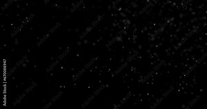 Magic Flying Particles. Small white particles flow in the air on a black background to simulate snow, blizzard, or a microcosm of the Christmas magic. Filmed at a speed of 120fps