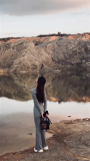 Woman Exploring Serene Lake in Stylish Jumpsuit