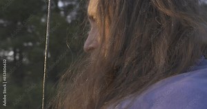 Portrait of a man with a beard in a medieval knight costume with a sword in front of his face. Close-up. Historical reconstruction.