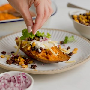 Warm and comforting baked kumara 😍 INGREDIENTS 4 medium orange kumara 2 cloves garlic, crushed 200g frozen corn kernels 400g can Wattie's® Black Beans in Springwater, drained and rinsed 1 tsp Gregg’s® Smoked Paprika 1 tsp Gregg’s® Ground Cumin ¾ cup grated tasty cheese ¾ cup sour cream ¼ red onion, finely diced Fresh coriander leaves METHOD Step 1. Preheat the oven to 190°C fan bake. Line a large baking tray with baking paper. Step 2. Cut the kumara in half horizontally and score the flesh. Pla