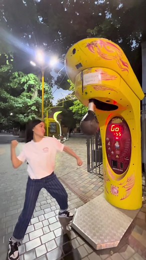Young Woman Takes on Vibrant Boxing Arcade Challenge