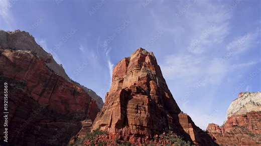 View zooming out from Angels landing while moving down the road from the passenger side of a vehicle.