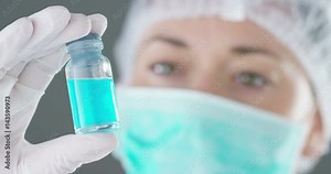 In a laboratory, a scientist with a pipette analyzes a colored liquid to extract the DNA and molecules in the test tubes. Concept: research, biochemistry, nature, pharmaceutical medicine