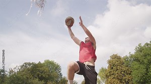 Basketball player slam dunking in slow motion
