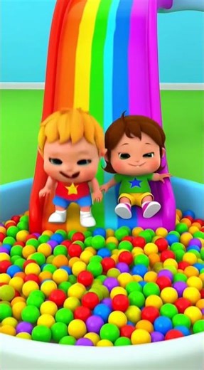 Kids slide down a rainbow slide into a ball pit.