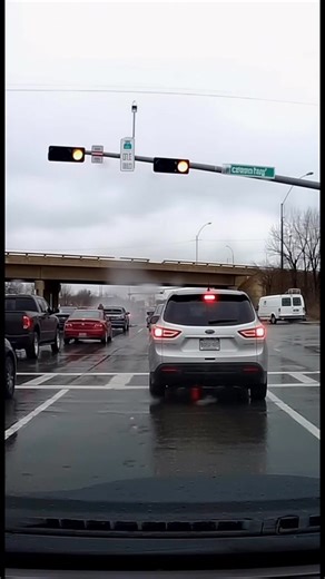 Dash cam footage captures a terrifying crash on a highway overpass. A car is seen speeding across an elevated overpass when it suddenly loses control, slamming into the guardrail. The impact sends the vehicle spinning violently, sparks flying as it crashes hard against the barrier. Below the overpass, traffic is completely stopped. Drivers look up in shock as debris falls near the edge, fearing the car might go over. The dash cam shakes as the crash unfolds just overhead, turning a routine commu