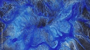 Fluid art footage with light blue and white overlapping colors. A closeup of swirling shine paint, with fluid patterns resembling an abstract painting. Abstract textures with sparkling sparkles.