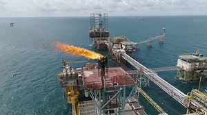 Aerial of gas flare on offshore oil processing plant