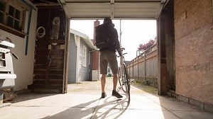 Lockdown shot of male commuter taking bicycle from garage